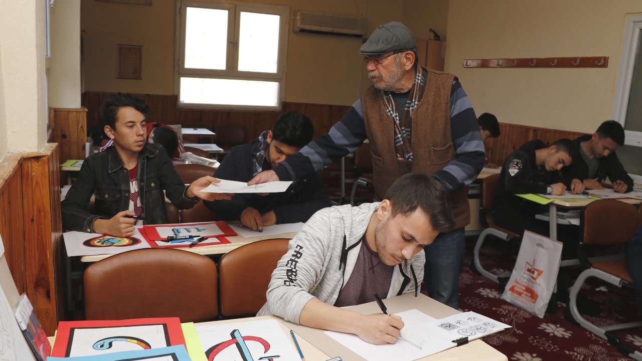 Kur'an-ı Kerim öğrenmek için kursa giden ressam, kursiyerlere hat öğretiyor