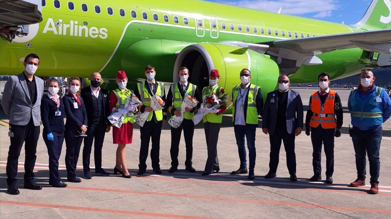 İlk uçakta bulunan turistlere çiçek ve lokum verildi